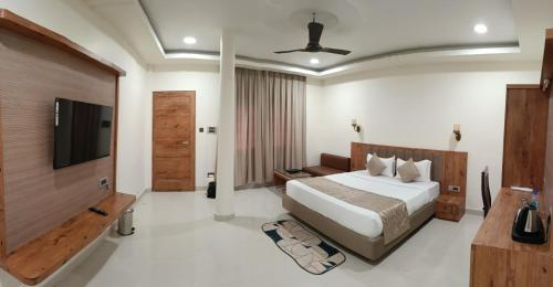 a bedroom with a bed and a flat screen tv at Hotel Royal Palace in Sāgar