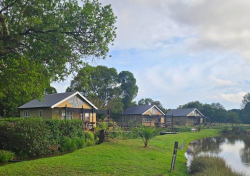 a row of cottages next to a river at Imbabali Retreat & Venue in Magaliesburg