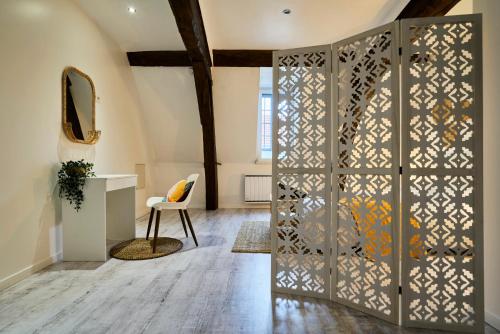 Cette chambre dispose d'une porte avec un miroir et une chaise. dans l'établissement T3 cosy avec terrasse à Douai, à Douai