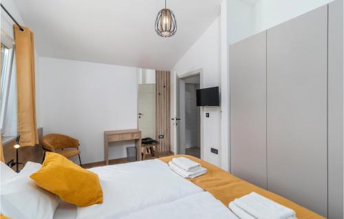 a bedroom with a large white bed with yellow sheets at 4 Bedroom Stunning Home In Lopar in Lopar