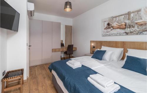 a bedroom with a large bed and a tv at 4 Bedroom Stunning Home In Lopar in Lopar