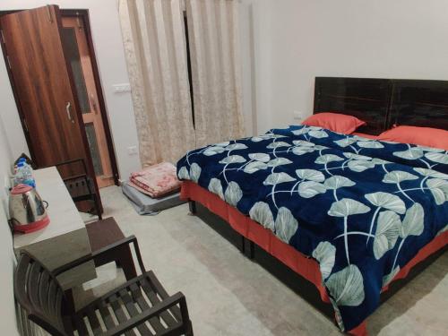 a bedroom with a bed and a table and a chair at Vasantvasoj Homestay in Pauri