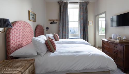 a bedroom with a large bed and a tv at The Black Bull Hotel in Duns