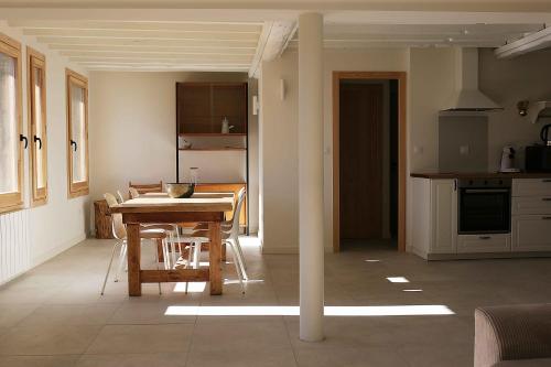 Una cocina y un comedor con mesa y sillas. en Appartement avec vue et jardin, en Formiguères