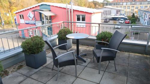 a patio with chairs and a table on a balcony at Hotel Spree-idyll in Berlin