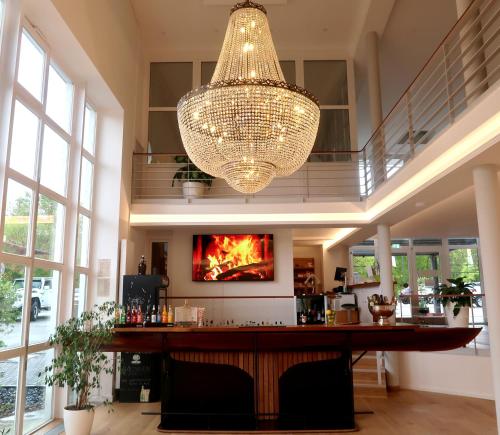 a bar with a chandelier hanging from a ceiling at Hotel Spree-idyll in Berlin