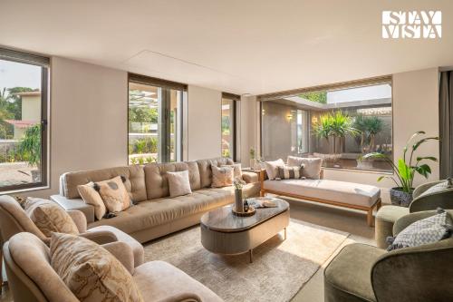 a living room with a couch and a table at StayVista at Solaris with Pool, Lawn & BBQ in Alibaug
