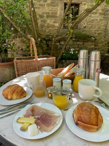 a table with plates of food and bread on it at Gîte d'exception - Manoir de Sacquenay in Sacquenay