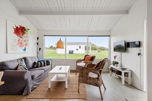 a living room with a couch and a table at Cozy Coastal Retreat on the beach in Brenderup