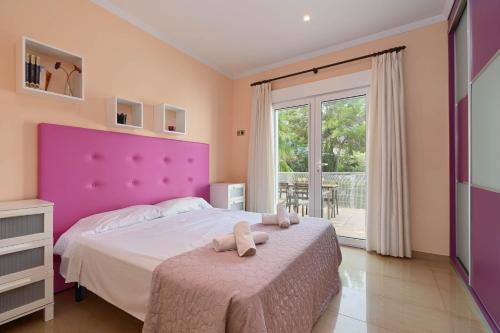 a bedroom with a large bed with a purple headboard at Villa Angels in Teulada