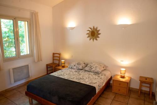 une chambre avec un lit et deux lampes et une fenêtre dans l'établissement Mini villa indépendante idéale et très bien située, à Porto-Vecchio