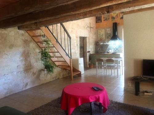 a living room with a red table and a staircase at Beloesieje gites in Castelsagrat