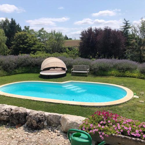 - une piscine dans une cour avec un banc et des fleurs dans l'établissement Beloesieje gites, à Castelsagrat