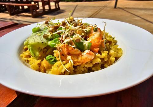 a white plate of food with shrimp and broccoli on rice at Imbabali Retreat & Venue in Magaliesburg