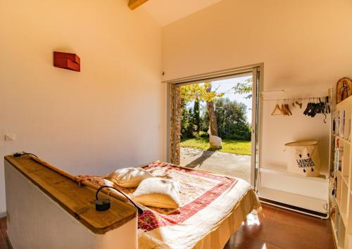 ein Schlafzimmer mit einem Bett und einer Glasschiebetür in der Unterkunft Maison Aux Vents in Monacia-dʼAullène