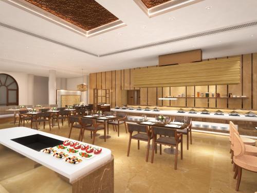 a restaurant with tables and chairs and a buffet at Taj Mahal Lucknow in Lucknow