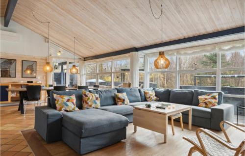un soggiorno con un divano blu e un tavolo di Cozy Home In Ålbæk With Kitchen ad Ålbæk