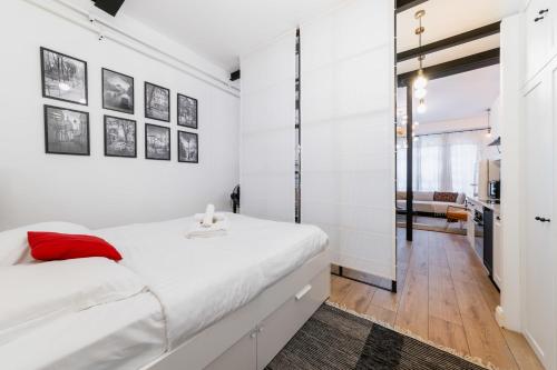 - une chambre avec des murs blancs et un lit avec un oreiller rouge dans l'établissement Charmant appartement équipé proche Sacre cœur - 4P - FLAT-GUEST, à Paris
