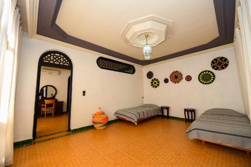 a room with two beds and a hallway with a ceiling at Targafit Hotel & Hammam in Marrakech