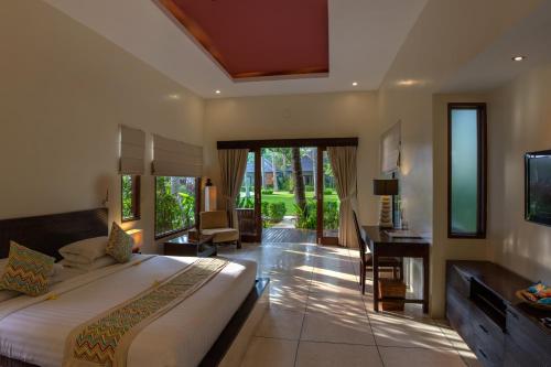 a bedroom with a bed and a desk in a room at The Chandi Boutique Resort & Spa in Senggigi
