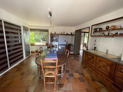 a kitchen with a table and chairs in a room at Maison 8 pers, piscine, au cœur du pays de Cognac in Malaville