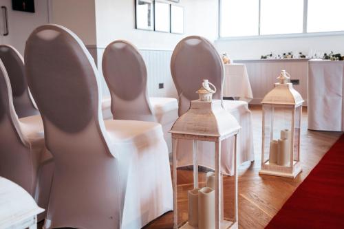a row of chairs in a room with white bows at Tiverton Hotel Lounge & Venue in Tiverton