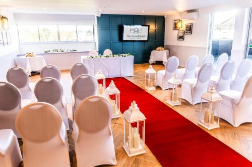a room with white chairs and a red carpet at Tiverton Hotel Lounge & Venue in Tiverton
