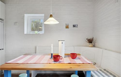 a dining room table with a candle and red cups at 3 Bedroom Gorgeous Home In Jerup in Jerup