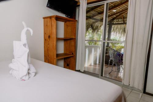 a white bed in a room with a window at Bungalows Zicatela in Puerto Escondido