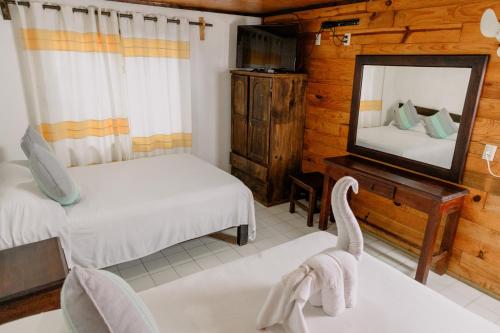 a bedroom with two beds and a mirror at Bungalows Zicatela in Puerto Escondido