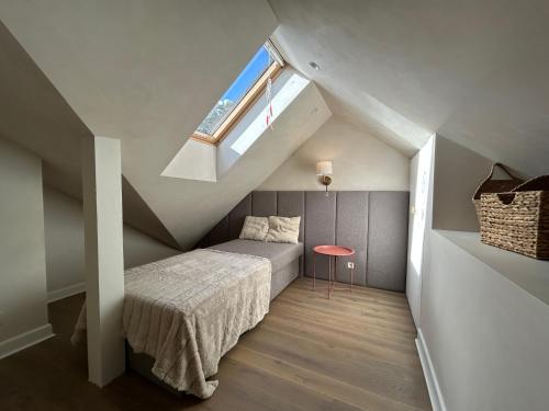 a attic bedroom with a bed and a window at CasaNida in Nida