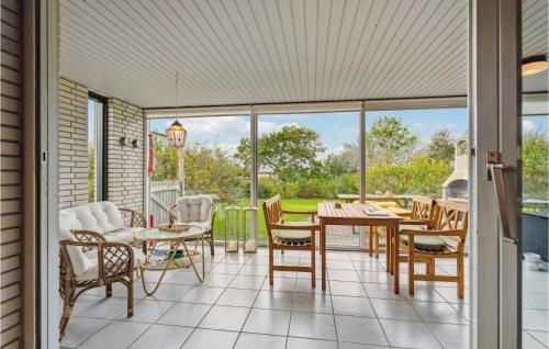a screened in porch with a table and chairs at 3 Bedroom Beautiful Home In Spøttrup in Spottrup