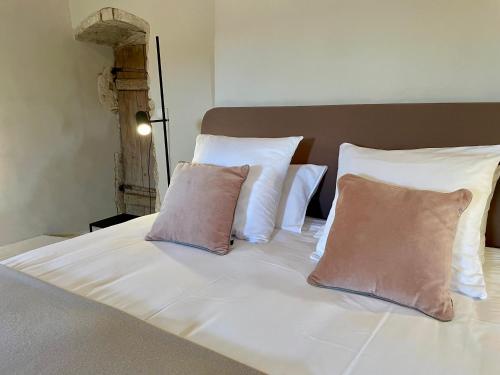 a white bed with two pillows on top of it at Gîte d'exception - Manoir de Sacquenay in Sacquenay