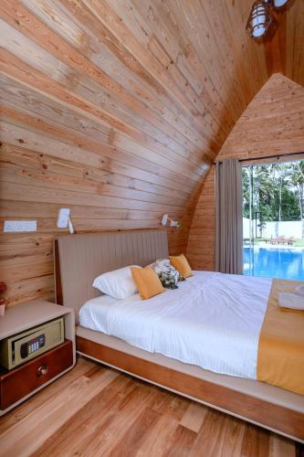 a bedroom with a bed in a wooden wall at Linasi Resort Sri Lanka in Ahangama