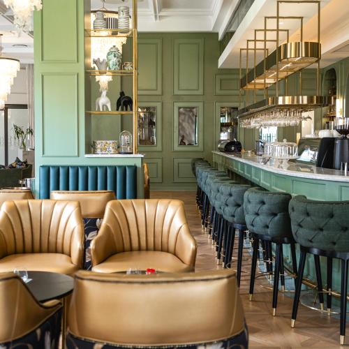 a bar with leather chairs and a counter in a restaurant at Steyn City Hotel by Saxon in Midrand