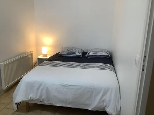 un lit avec deux oreillers dessus dans une chambre dans l'établissement Studio Kennedy, à Trouville-sur-Mer