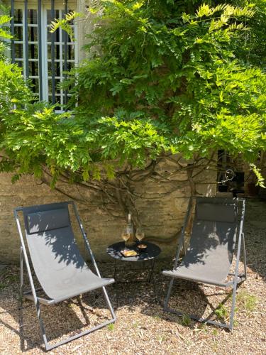 two chairs and a table in front of a tree at Gîte d'exception - Manoir de Sacquenay in Sacquenay