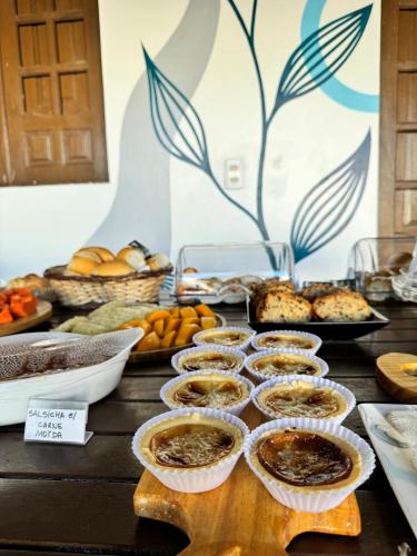 a table with pies and other food on it at Pousada Costamar in Maragogi