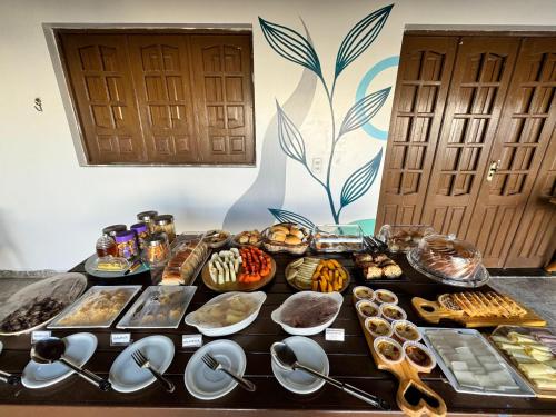a table topped with lots of different types of food at Pousada Costamar in Maragogi