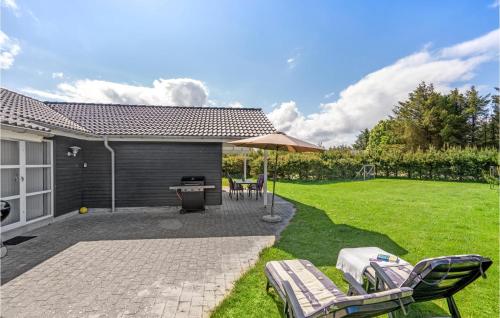 a patio with chairs and a grill in a yard at Holiday Home Toftevej in Løkken