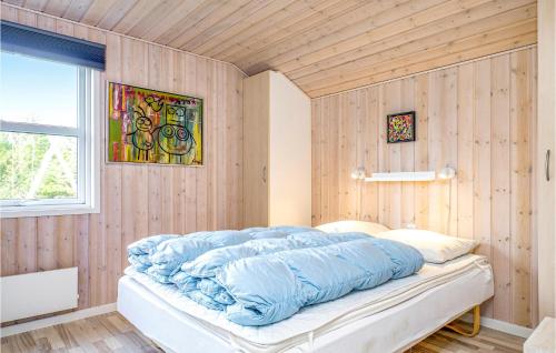 a bedroom with a large blue comforter on a bed at Holiday Home Toftevej in Løkken