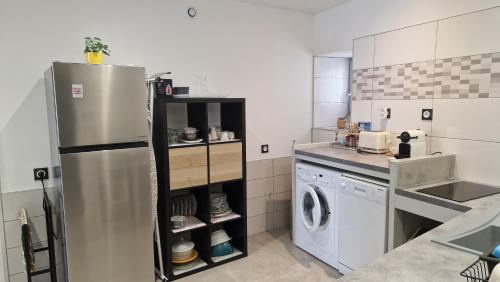 a kitchen with a refrigerator and a washing machine at Votre gîte au Domaine du Lynx in Baume-les-Messieurs
