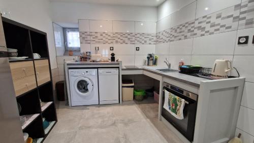 a kitchen with a washing machine and a sink at Votre gîte au Domaine du Lynx in Baume-les-Messieurs