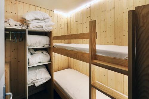 une chambre avec plusieurs lits superposés dans une pièce dans l'établissement Le ptit vosgien - Appt à 15min des pistes, à La Bresse