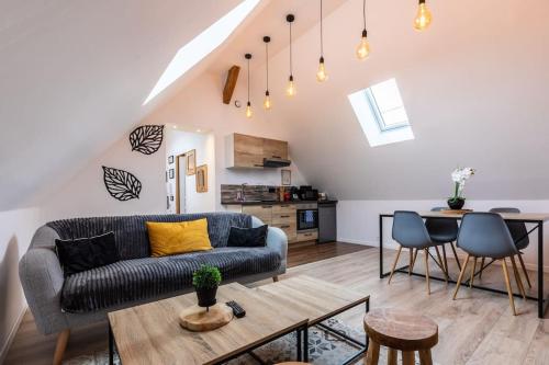 un salon avec un canapé et une table dans l'établissement Gîte Cosy Jacuzzi privatif proche Paris et Giverny, à La Boissière