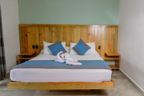 a bed with two stuffed animals laying on it at Bungalows Zicatela in Puerto Escondido