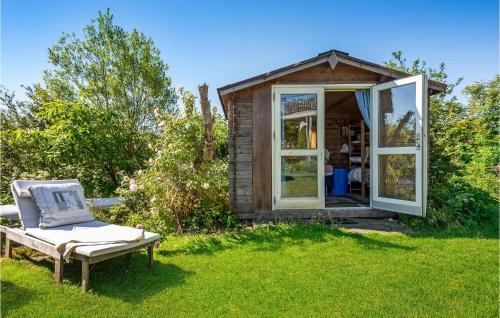 a small shed with a chair in the grass at 2 Bedroom Cozy Home In Egå in Egå