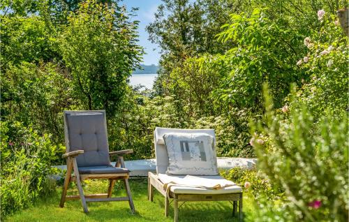 two chairs sitting next to each other in a yard at 2 Bedroom Cozy Home In Egå in Egå