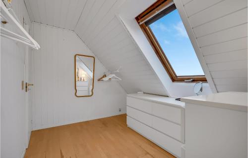 a bathroom with white cabinets and a window at 2 Bedroom Cozy Home In Egå in Egå