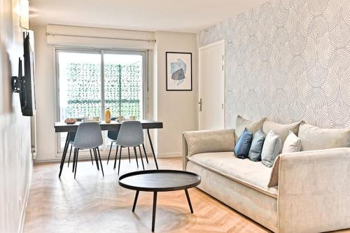 un salon avec un canapé et une table dans l'établissement Appartement spacieux et paisible Paris 19ème - II, à Paris